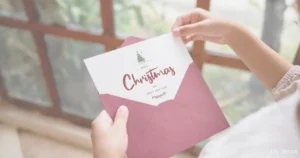 Photo of a person holding an envelope pulling out a christmas card from the enevelope