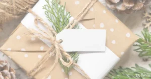 Photo of a christmas gift wrapped in lovely brown paper with decor and a gift tag ready to be filled in