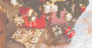 Photo of some gifts nicely wrapped and stacked under a Christmas tree