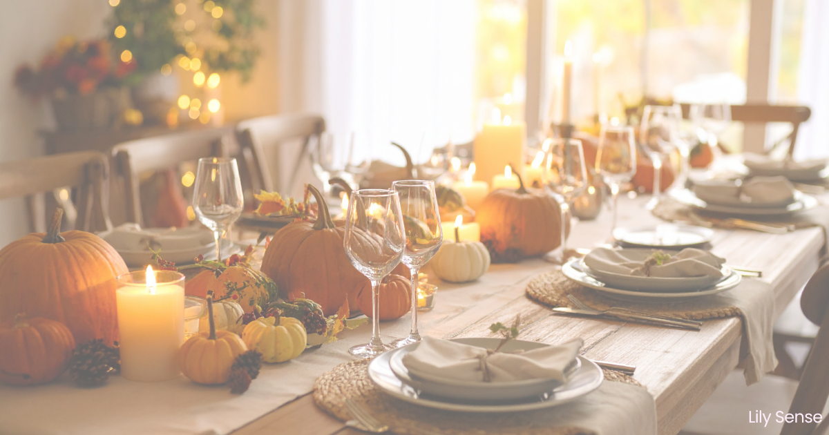 A photo of a beautiful decorated and set table for Thanksgiving. Light from the window in the background filters in.